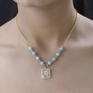 Closeup of woman modeling Sleeping Beauty Turquoise and Moissanite Celestial Medallion Necklace.